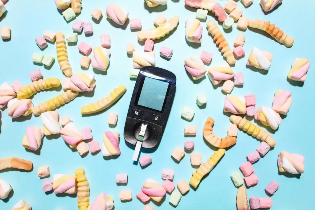Colorful arrangement of candies and a glucose meter illustrating diabetes management.