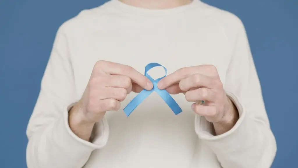 A person holding a blue awareness ribbon symbolizing support for various causes.